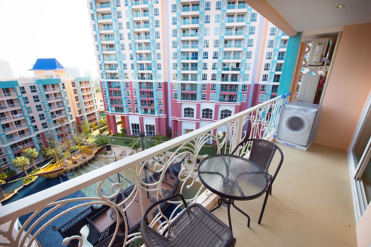 Un balcon donnant sur un plan d’eau et des immeubles de grande hauteur.