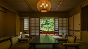 Une pièce de style japonais traditionnel, avec un sol recouvert de tatamis, une table basse et des paravents en papier de riz (shoji).