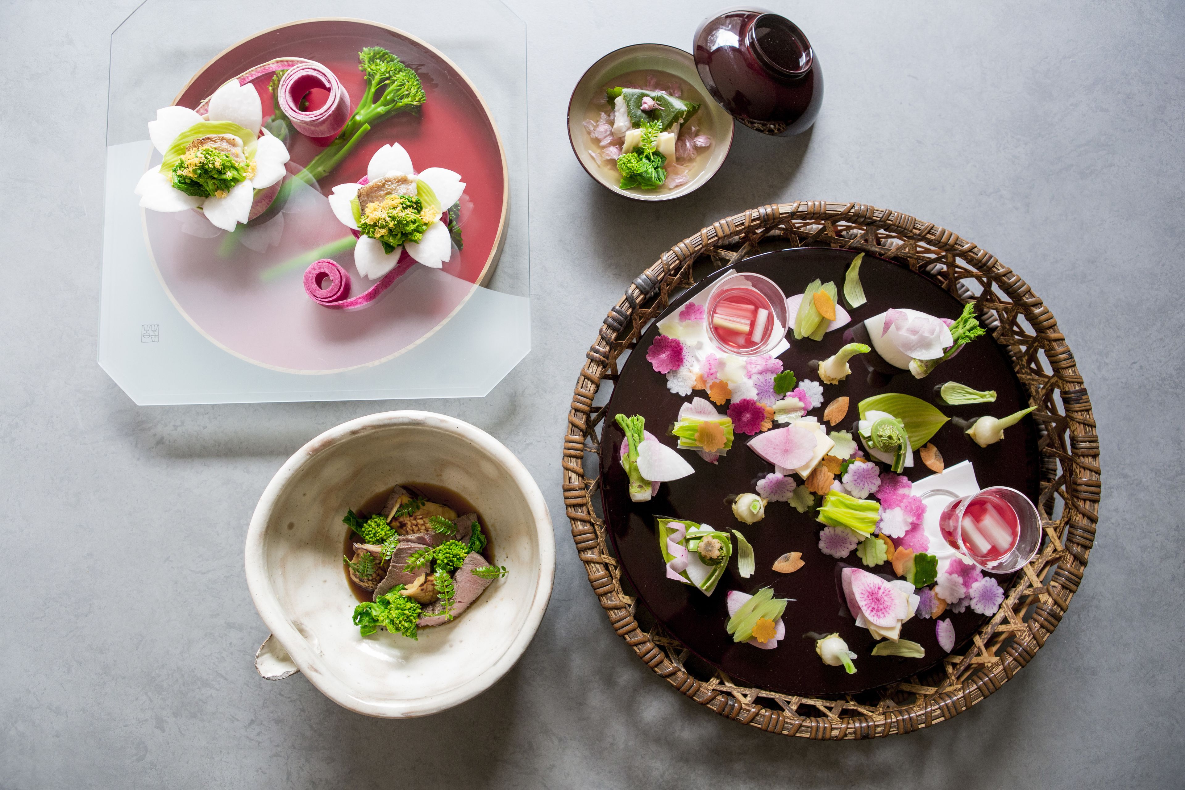 Een eettafel gedekt met een bord eten, een soepkom en een decoratieve dienblad met bloemen en een drankje.