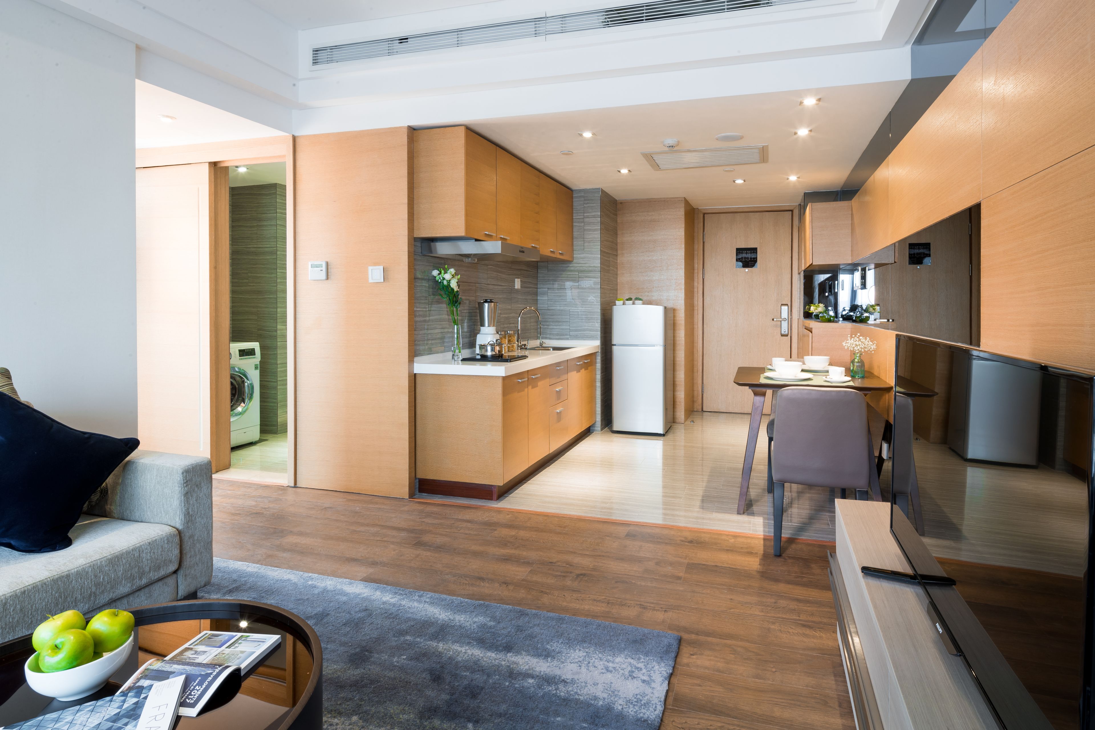 A modern kitchen with wooden cabinets, a built-in stove, and a refrigerator.