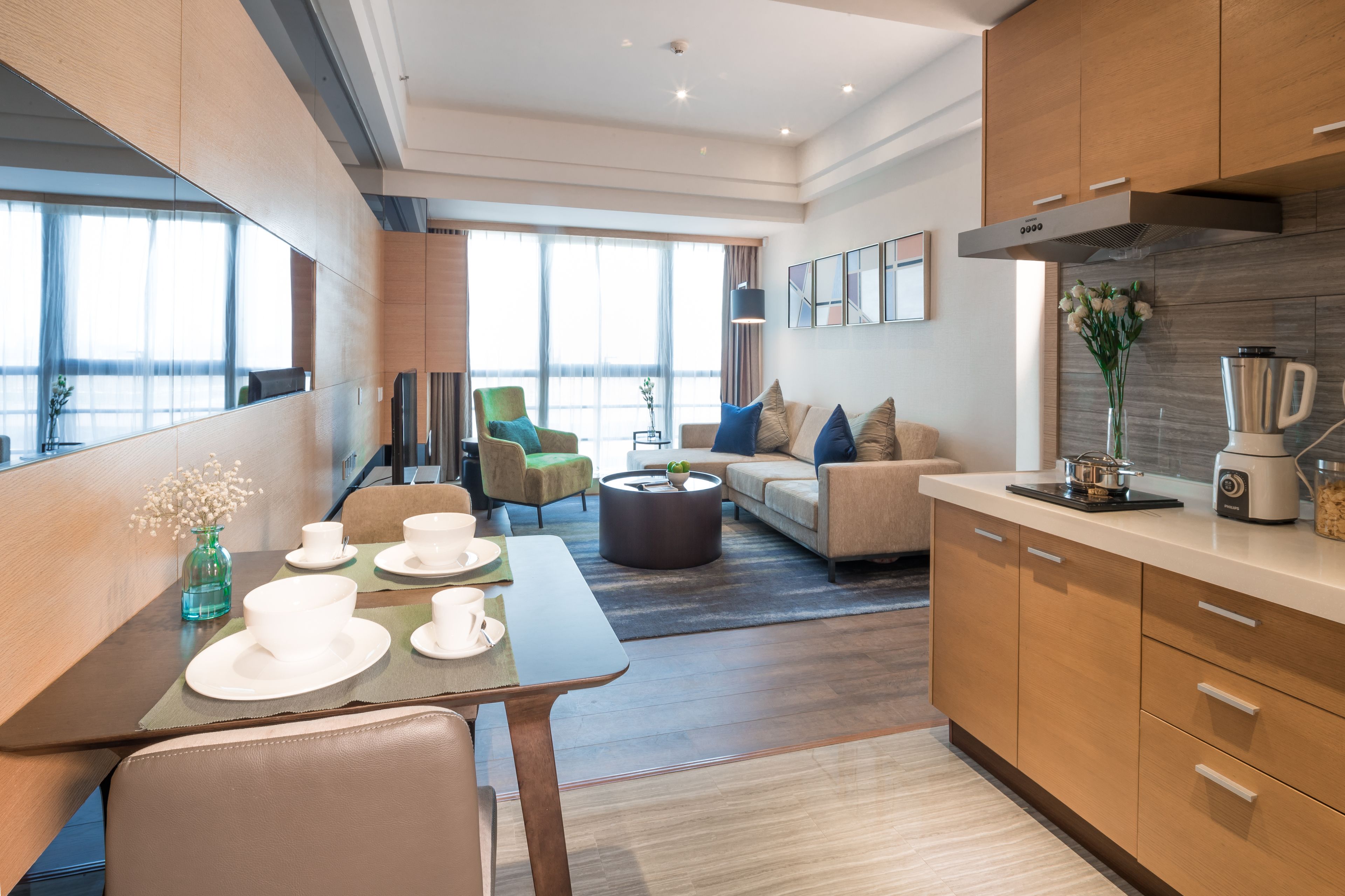 A modern kitchen with a dining area, a sofa, and a coffee table.
