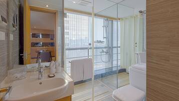A modern bathroom with a glass-enclosed shower, a white sink, and a toilet.
