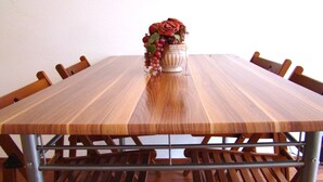 Taula rectangular de fusta amb un ram de roses vermelles i raïms.
