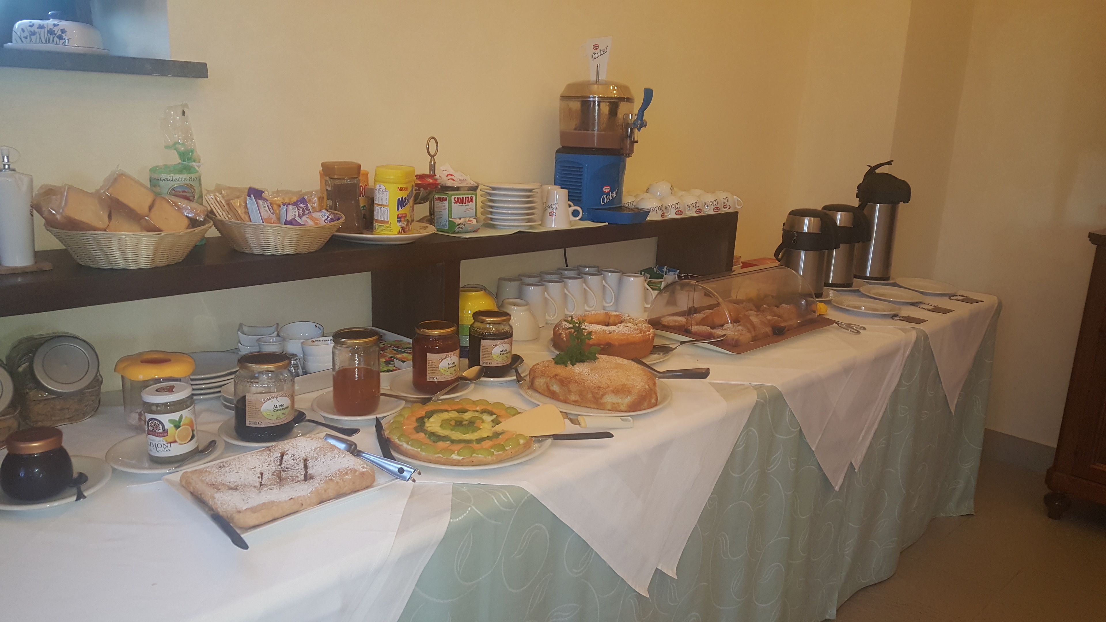 A buffet table with various food items, condiments, and utensils.