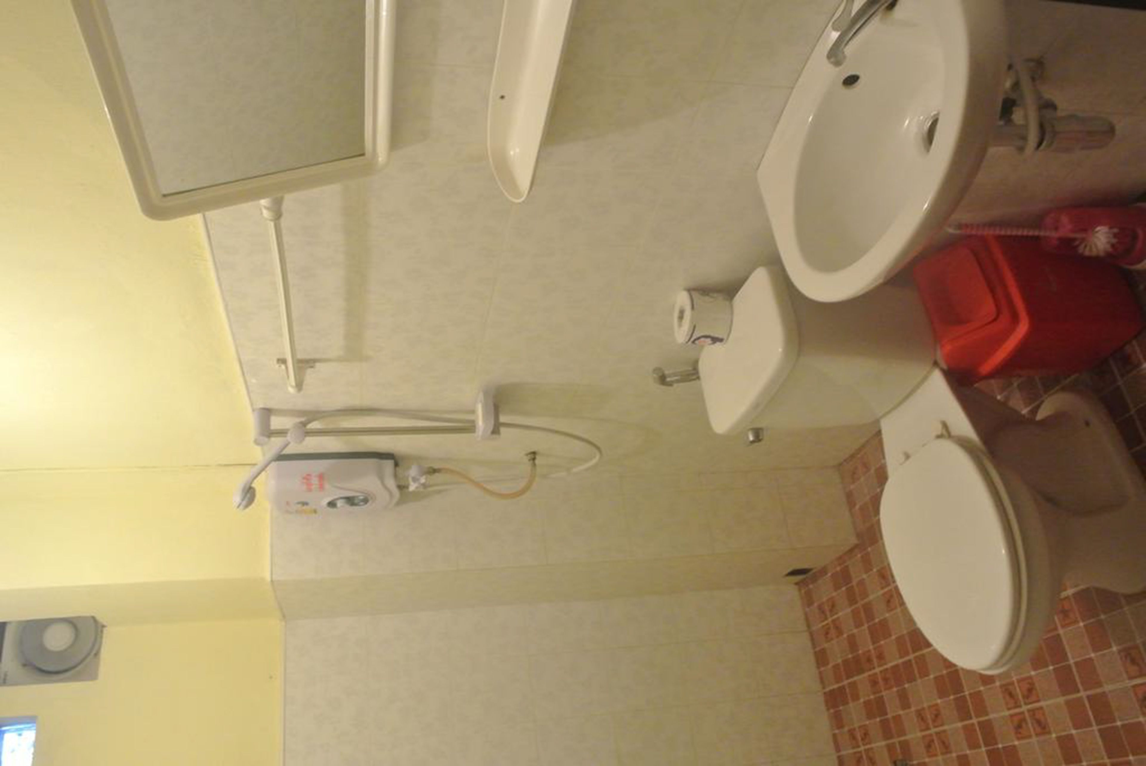Ein Badezimmer mit Toilette, Waschbecken und Spiegel.