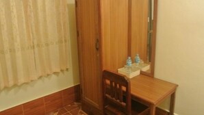Un mueble de madera con espejo, una pequeña mesa de madera y una silla.