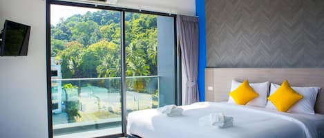 Une chambre dâhĂŽtel avec un lit, une grande fenĂȘtre et une vue sur la verdure.