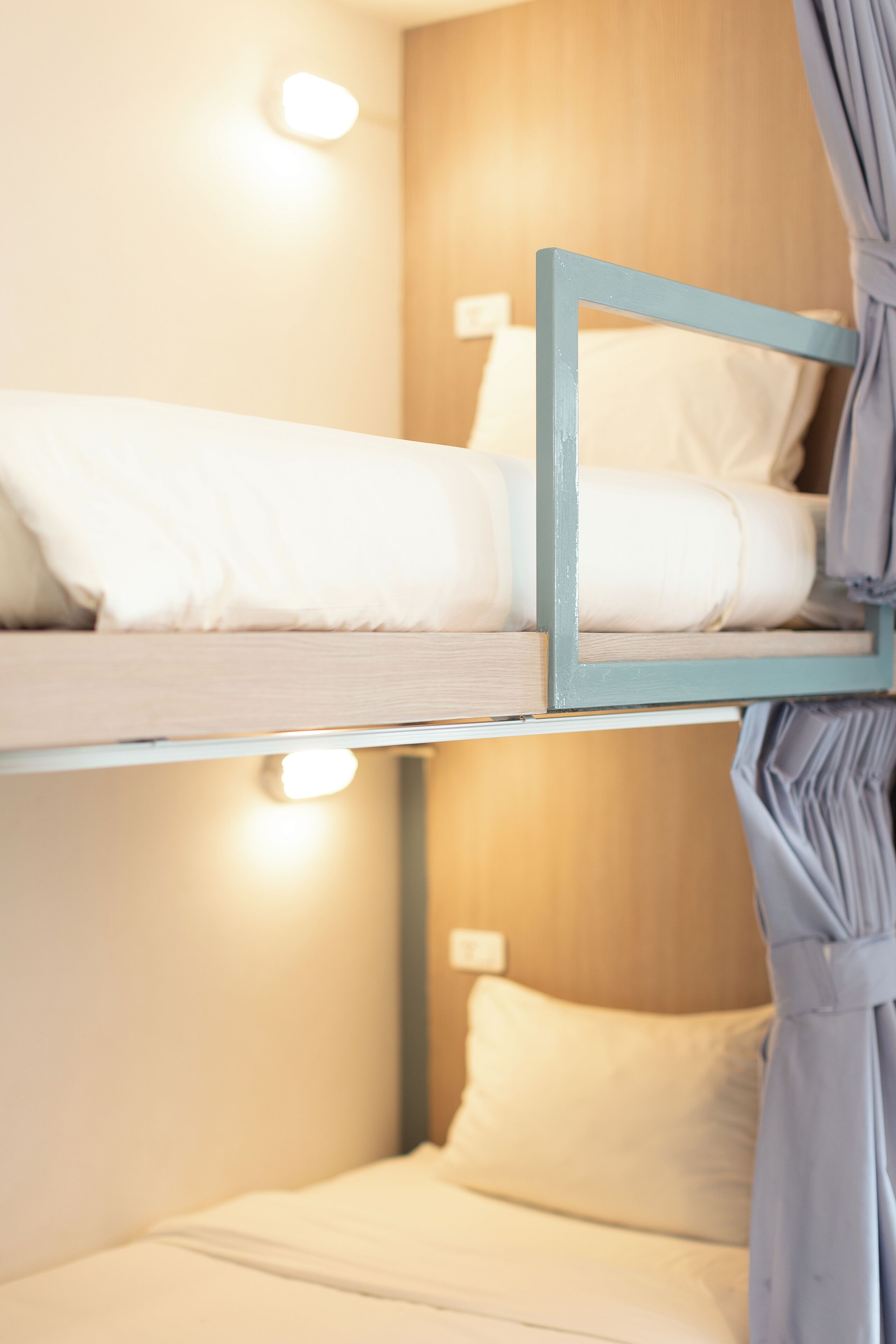 A bunk bed with white bedding and a light blue frame.