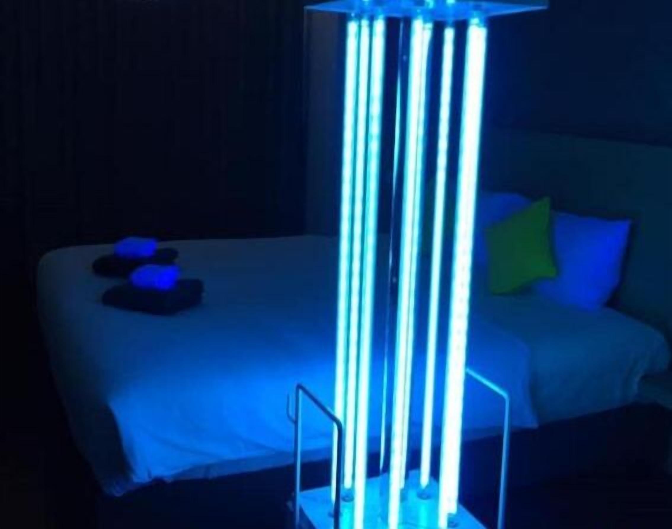 Un lit avec un drap blanc, un oreiller bleu et une table de chevet sur laquelle se trouve un objet bleu.