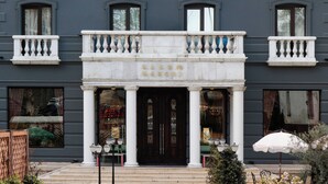 A building facade with a central entrance, multiple windows, and a balcony with balustrades. - Margot Old Tbilisi (Tbilisi)