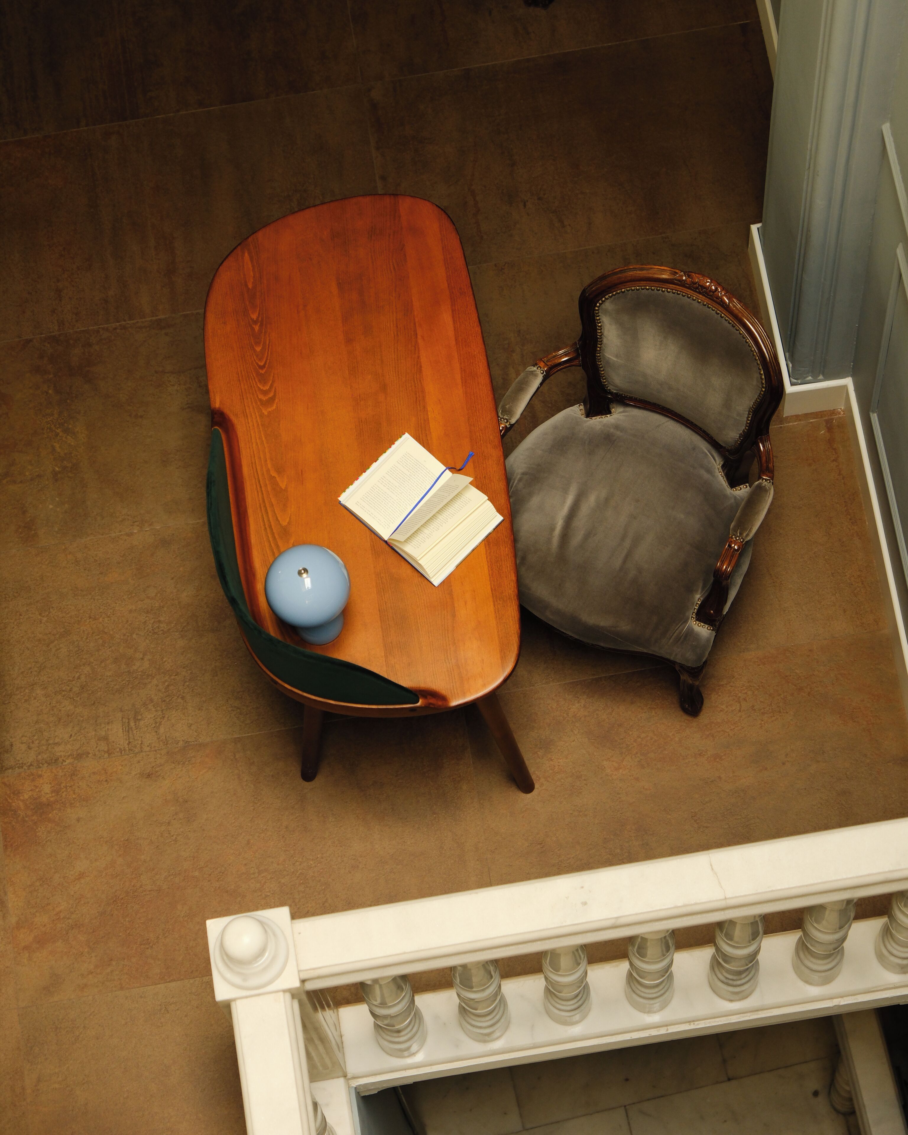 A room with a wooden table, a chair, and a lamp.