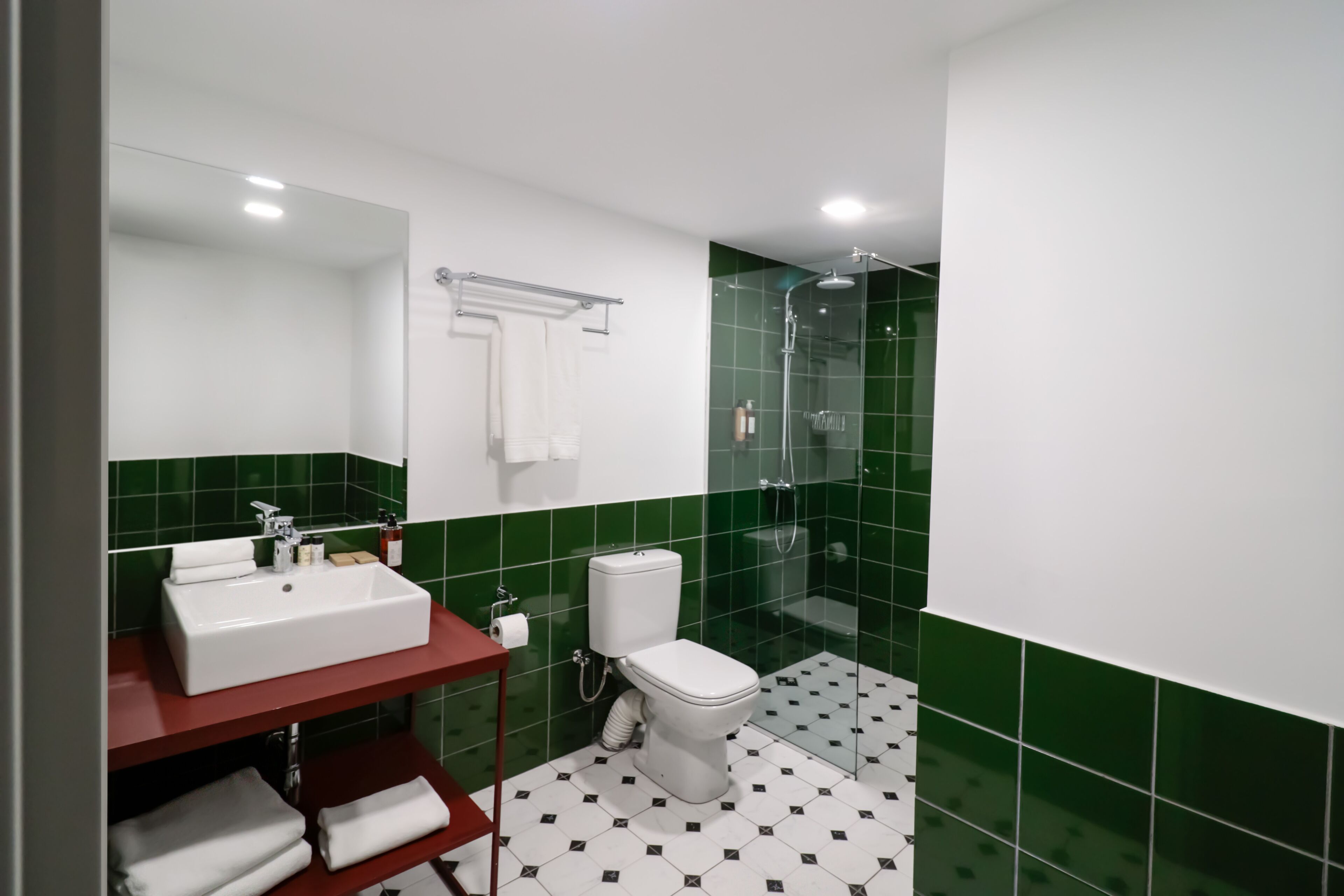 A modern bathroom with a white sink, toilet, and shower.