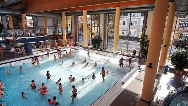 A large indoor swimming pool with multiple lanes, surrounded by large windows and columns. - Hotel Mühlhäuser Hof (Mühlhausen/Thüringen)