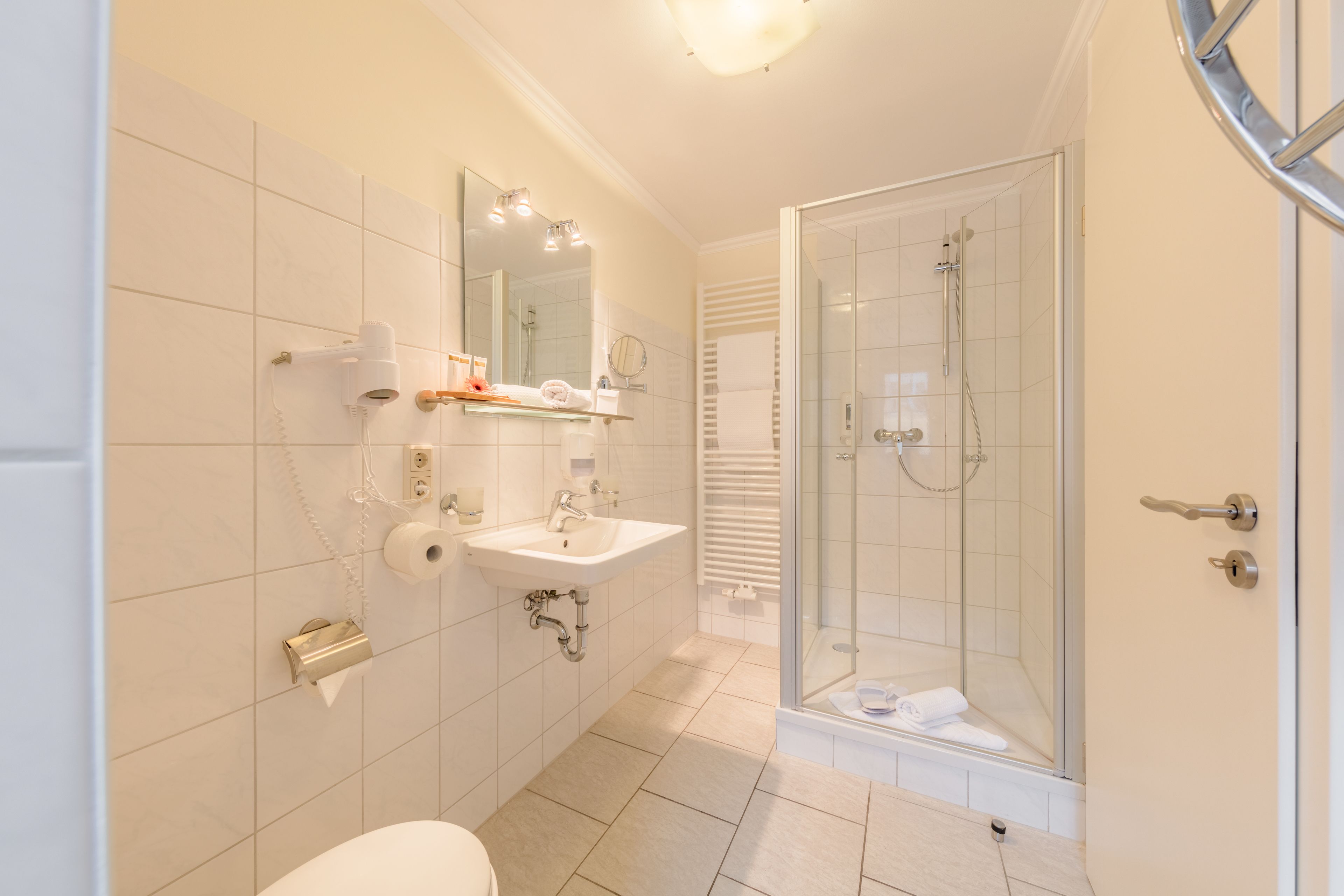 Ein modernes Badezimmer mit Toilette, Waschbecken und einer Duschkabine.