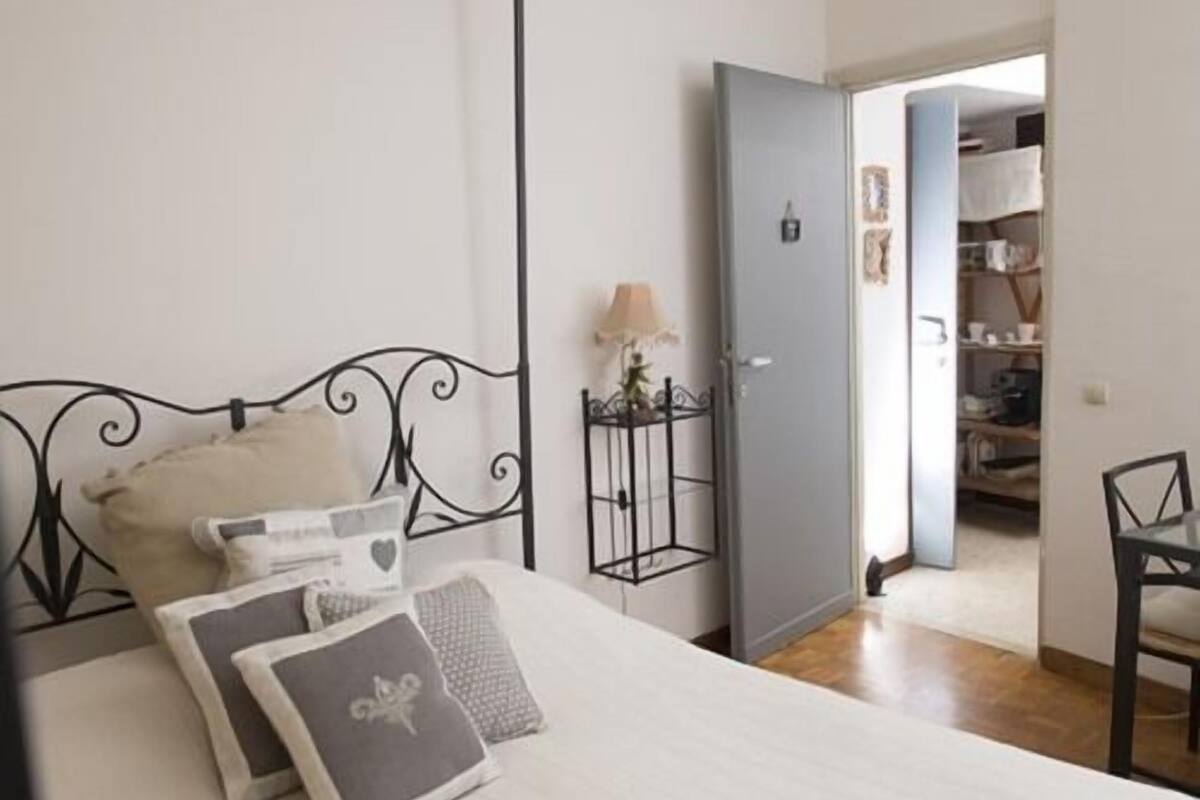 Une chambre à coucher comprenant un lit, une table de chevet, une lampe et une armoire.