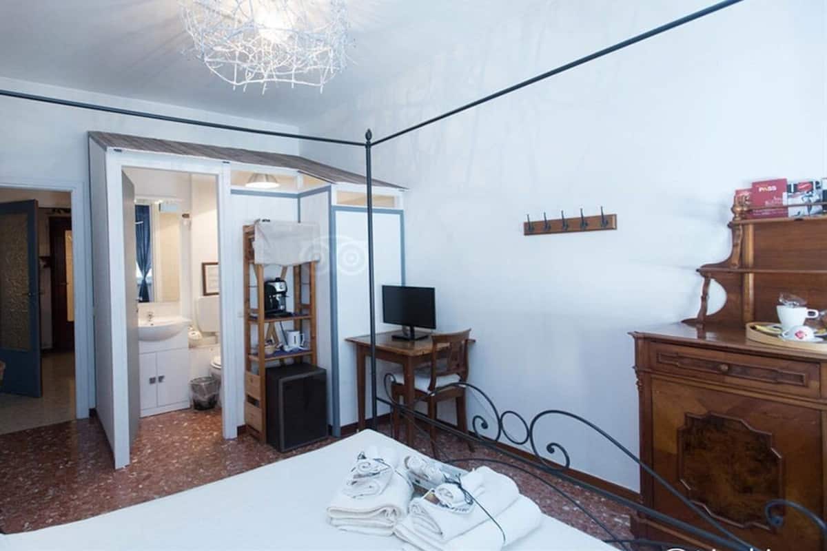 Une chambre d’hôtel équipée d’un lit, d’un bureau, d’une chaise, d’une télévision et d’une armoire.