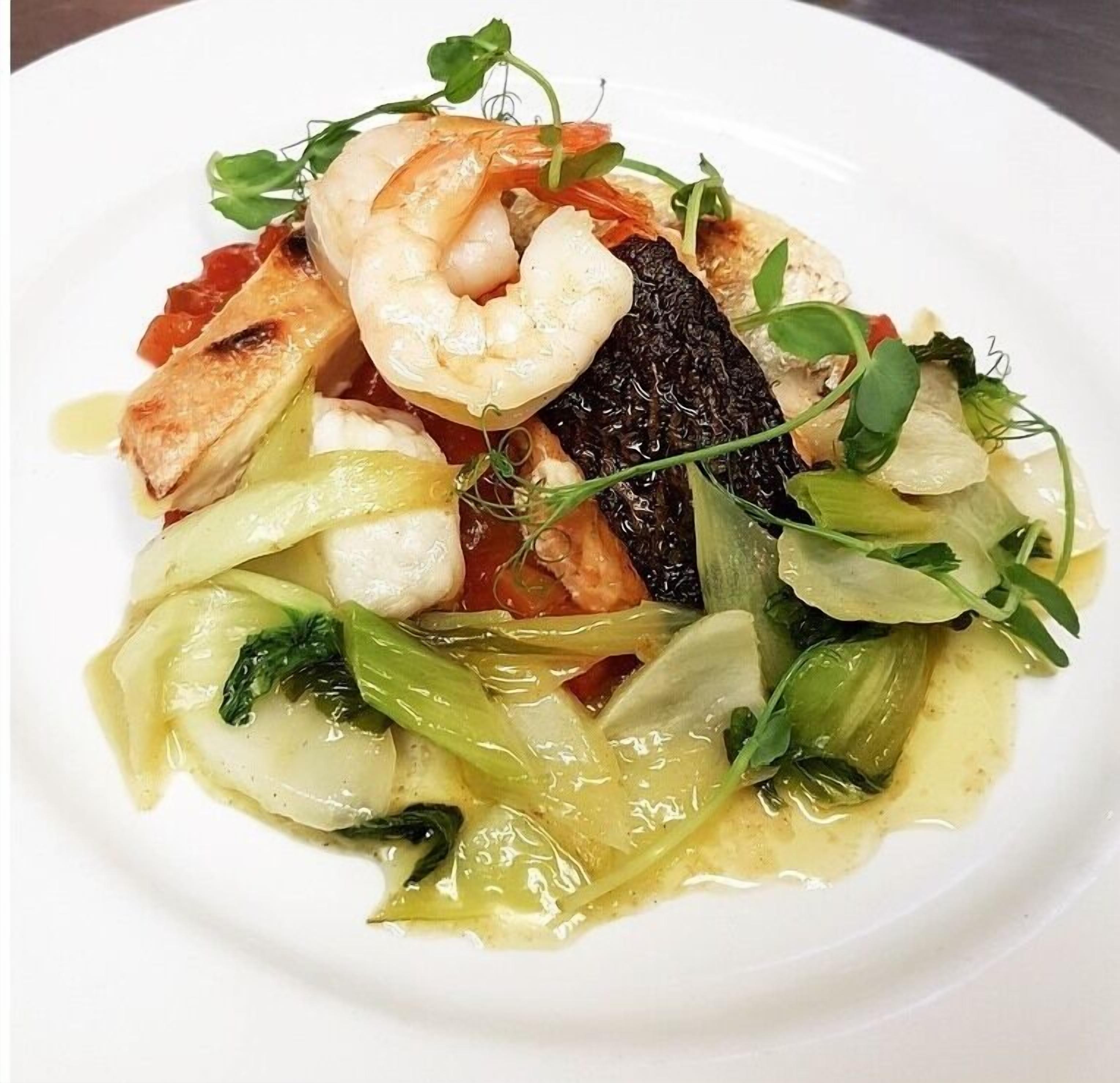 A plate of food with shrimp, fish, and vegetables.