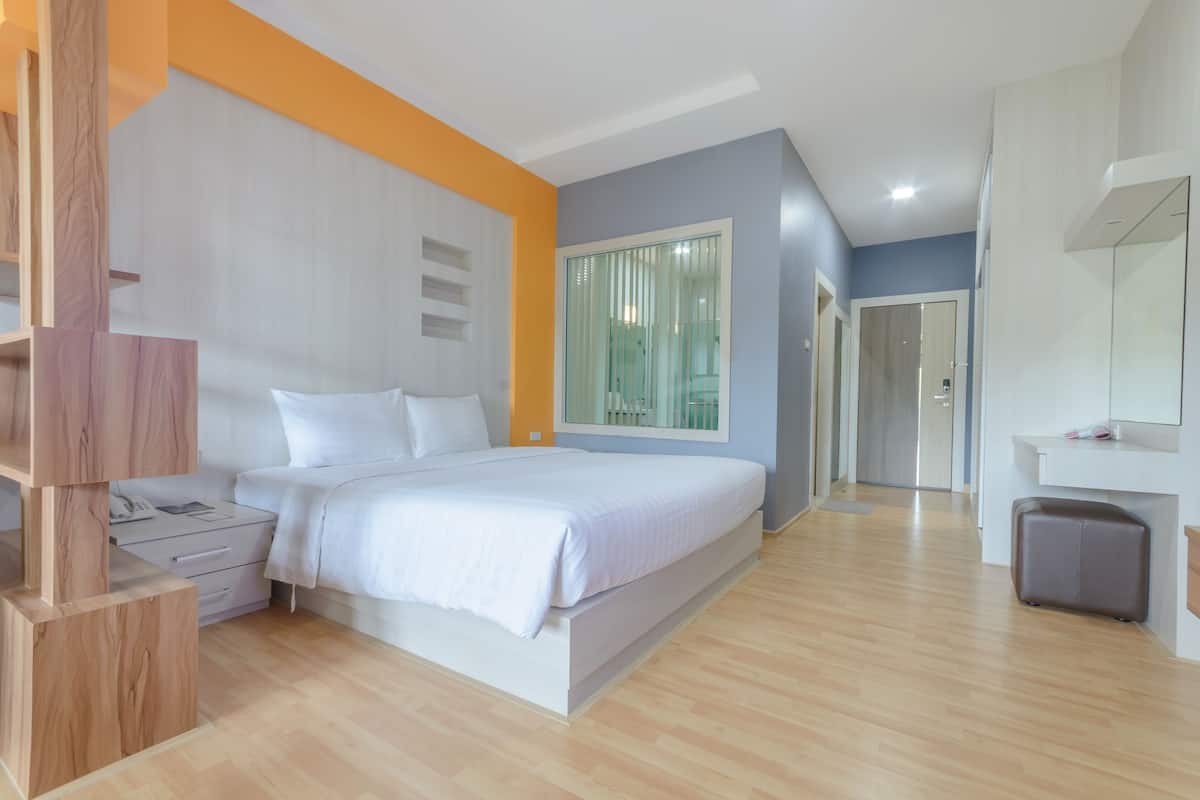 Een moderne slaapkamer met een bed, nachtkastjes, een kledingkast en een groot raam.