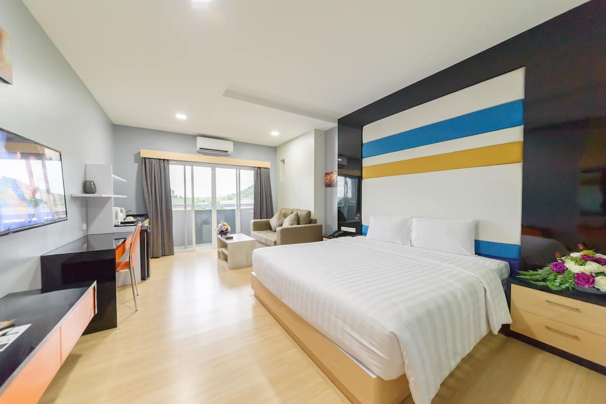 Een moderne hotelkamer met een groot bed, een bureau, een bank en een televisie.