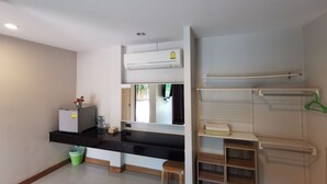 A compact kitchen with a black countertop, a white refrigerator, a small sink, and a green trash bin. - Smile Resort Sriracha (Si Racha)