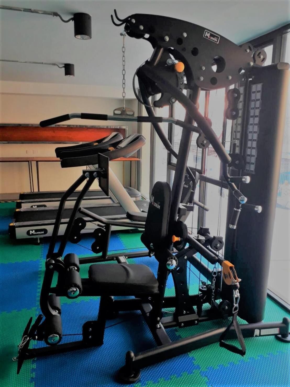 A gym with a variety of exercise machines, including a leg press and a chest press.