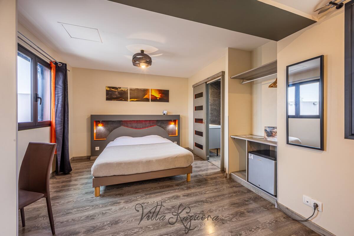Une chambre à coucher moderne, avec un lit, un bureau et une armoire.
