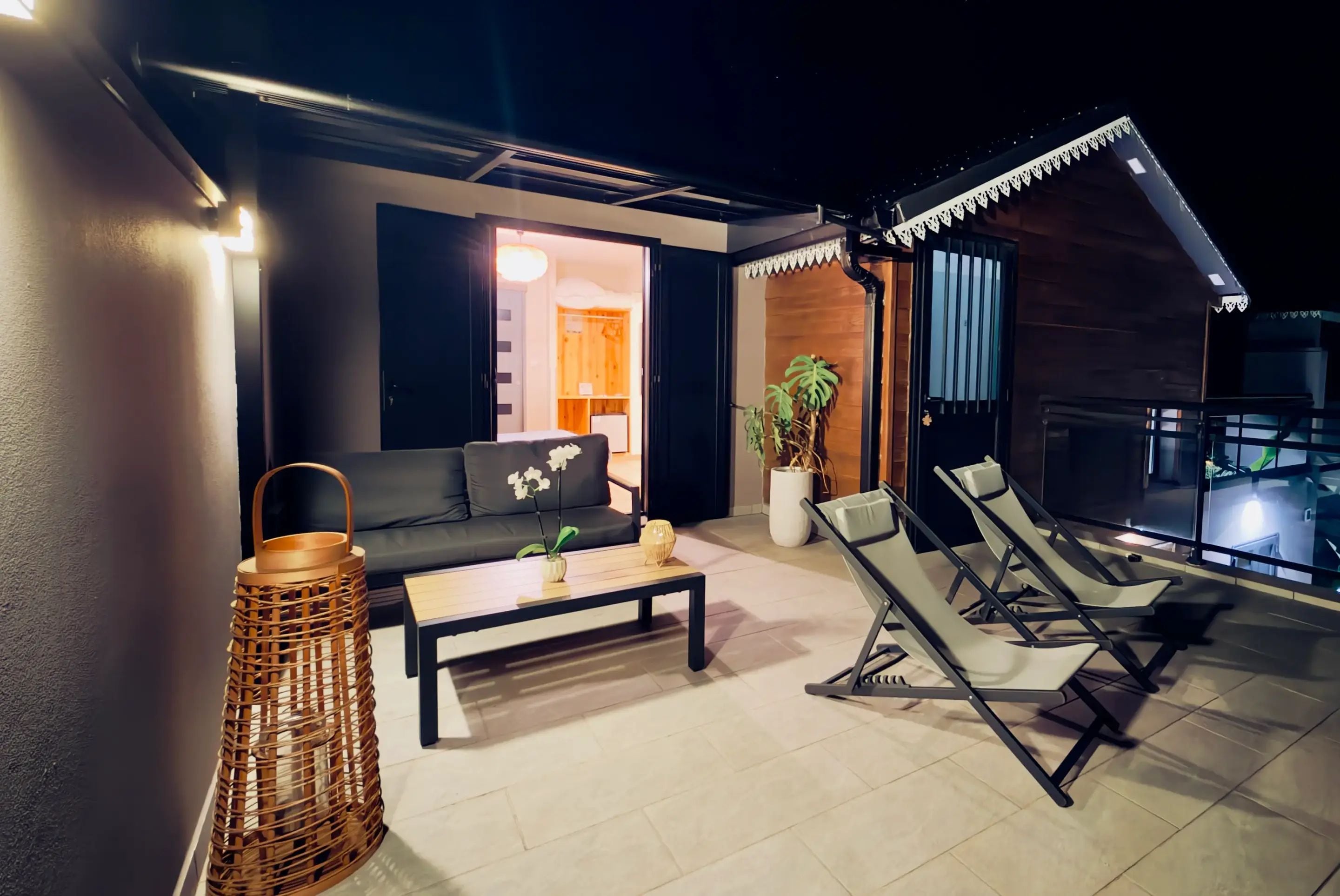 Una zona salotto esterna moderna con un divano, poltrone e un tavolino.