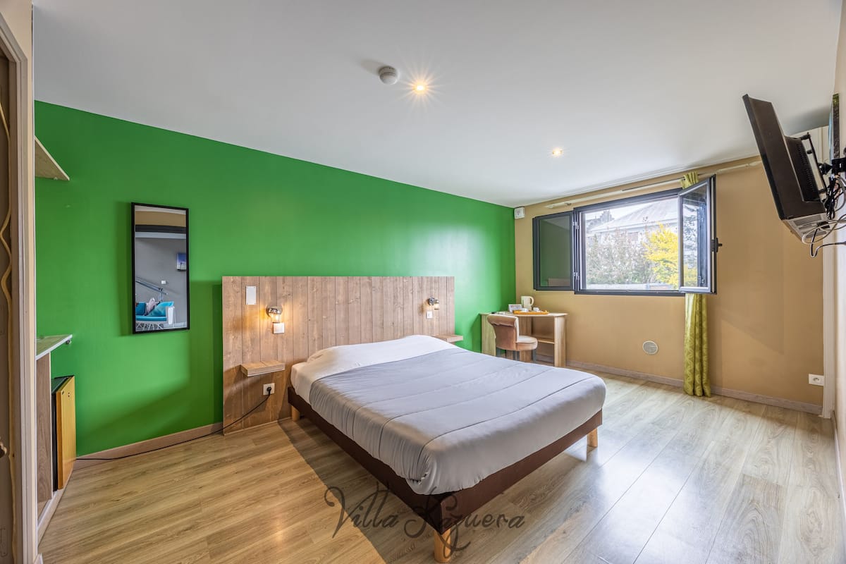 Une chambre à coucher avec un lit, un bureau et une fenêtre.