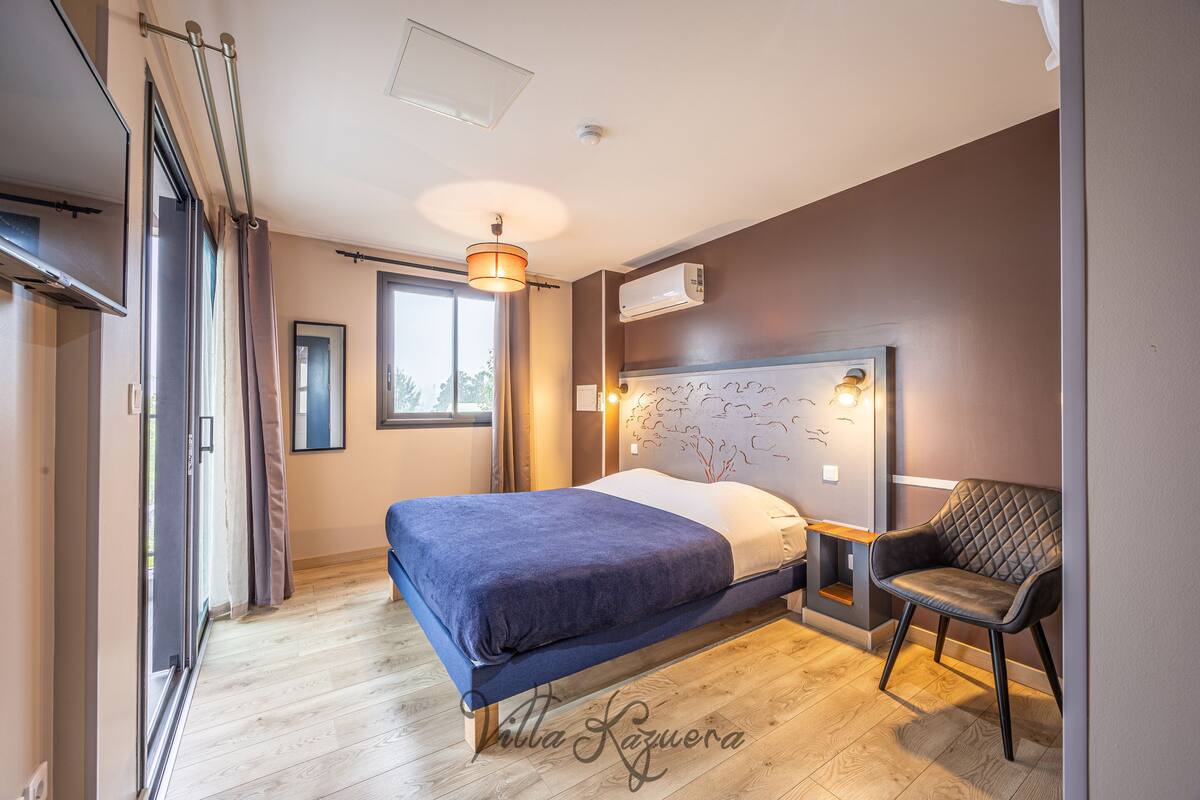 Une chambre à coucher comprenant un lit, une chaise, une fenêtre et un appareil de climatisation.