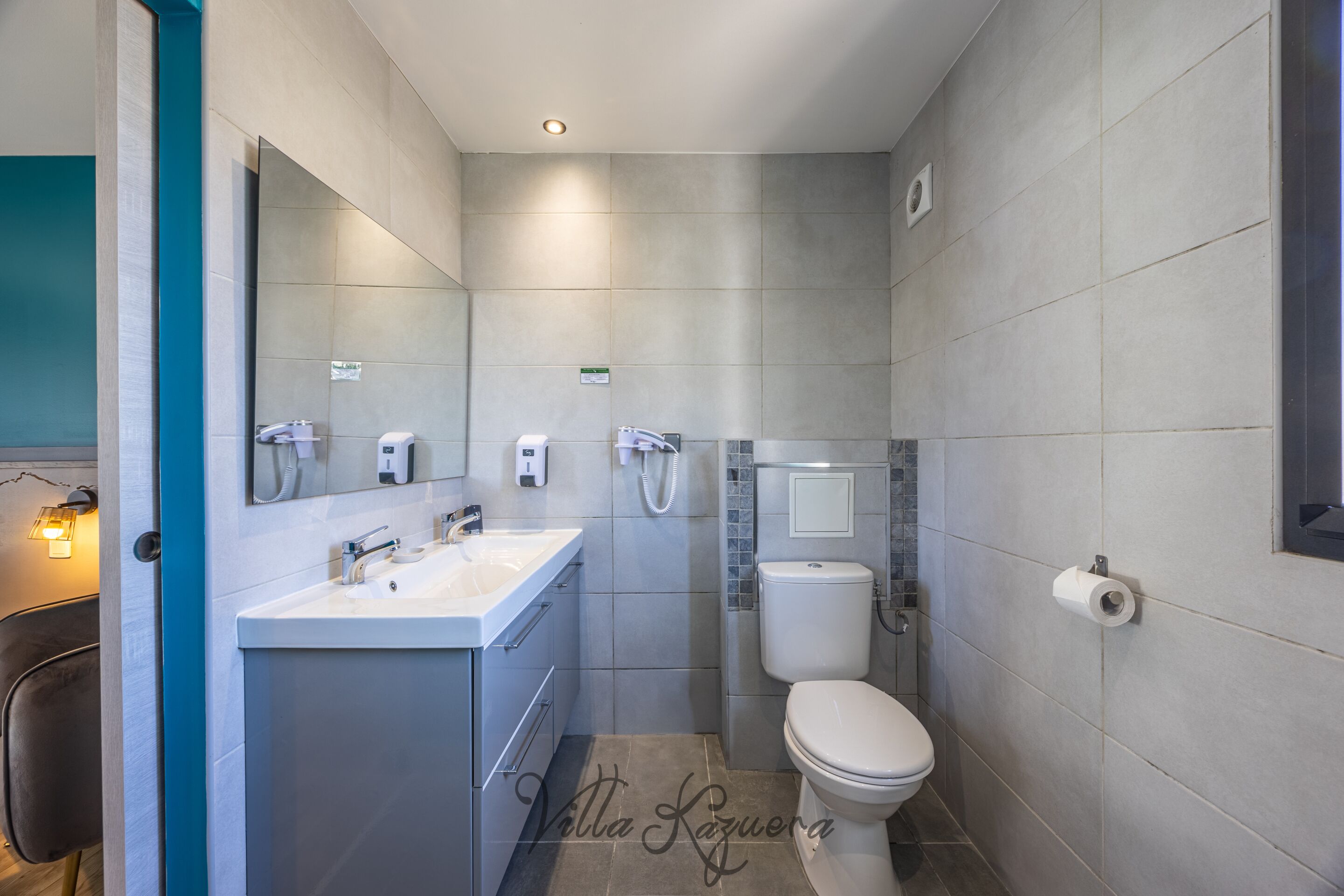 Ein modernes Badezimmer mit Waschbecken, Spiegel, Toilette und Dusche.