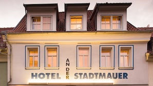 Un edificio de dos pisos con un letrero que dice 'HOTEL STADTMAUER'.