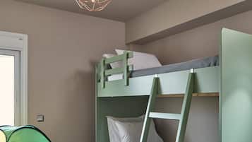 A bunk bed with a ladder, a play tent, and a rocking horse in a room with wooden flooring.