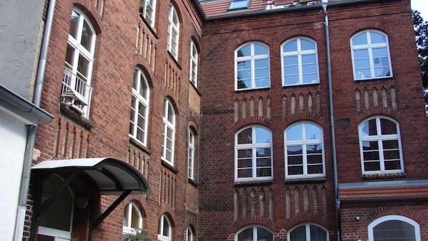 A multi-story brick building with arched windows and a flat roof. - Ferienwohnung Backstube König (Brandenburg an der Havel)
