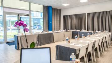 A conference room with a long table, chairs, water bottles, and a laptop.