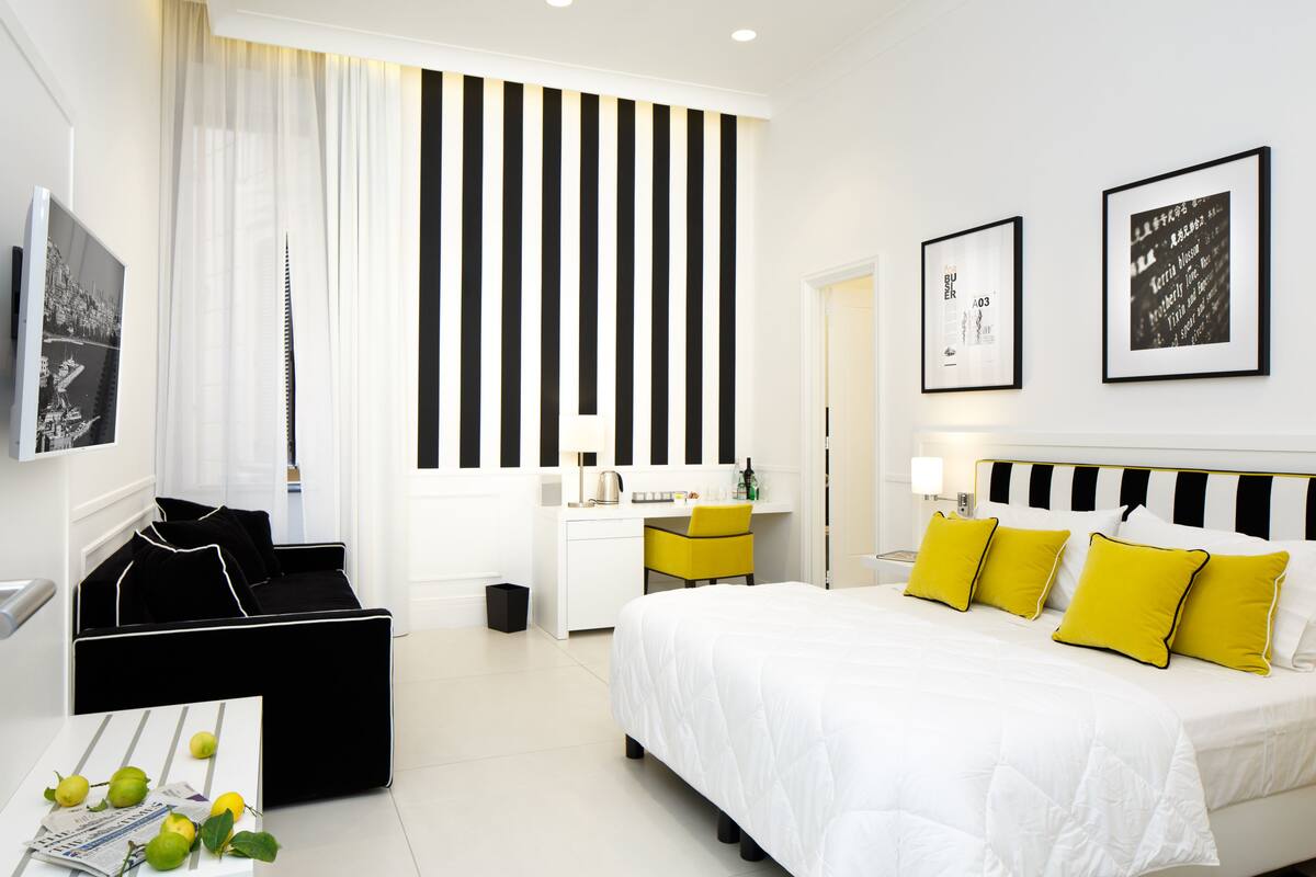 Une chambre d’hôtel moderne, dotée d’un grand lit, d’un bureau et d’un coin salon.