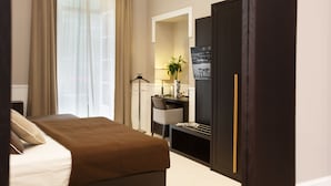 A hotel room with a bed, a desk, a chair, a mirror, and a wardrobe. - Nap Luxury Guest House (Naples)