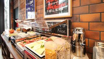 A buffet with various food items and condiments, including a coffee machine and a milk dispenser.