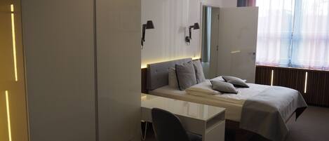 Una habitación de hotel moderna con una cama, un escritorio y una silla.