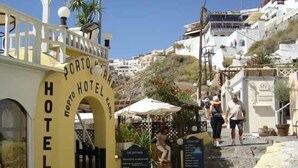 A coastal hotel entrance with a sign reading "HOTEL" and "PORTO". - Hotel Porto Carra (Santorini)
