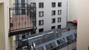 Een meerlaags gebouw met een balkon, grote ramen en een plat dak.