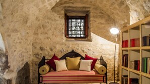 A cozy room with a bed, a small window, and a bookshelf. - Il Borgo dell'Arcangelo (Tuili)