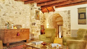 A rustic room with stone walls, wooden furniture, and a traditional lamp. - Il Borgo dell'Arcangelo (Tuili)
