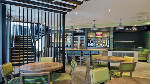 Un intérieur moderne comprenant un bar, des espaces de détente et un escalier.