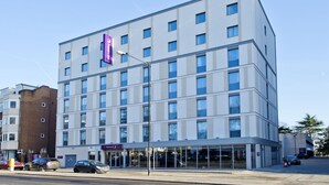 A modern hotel with a flat facade, large windows, and a prominent purple sign. - Premier Inn Slough Central South (Slough)