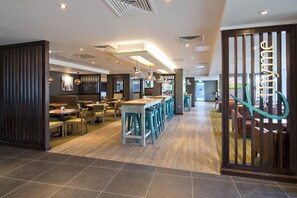A modern restaurant with high tables, bar stools, and pendant lighting. - Premier Inn Slough Central South (Slough)