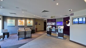 A hotel lobby with seating, a check-in counter, and a 'Good Night Guarantee' sign. - Premier Inn Slough Central South (Slough)