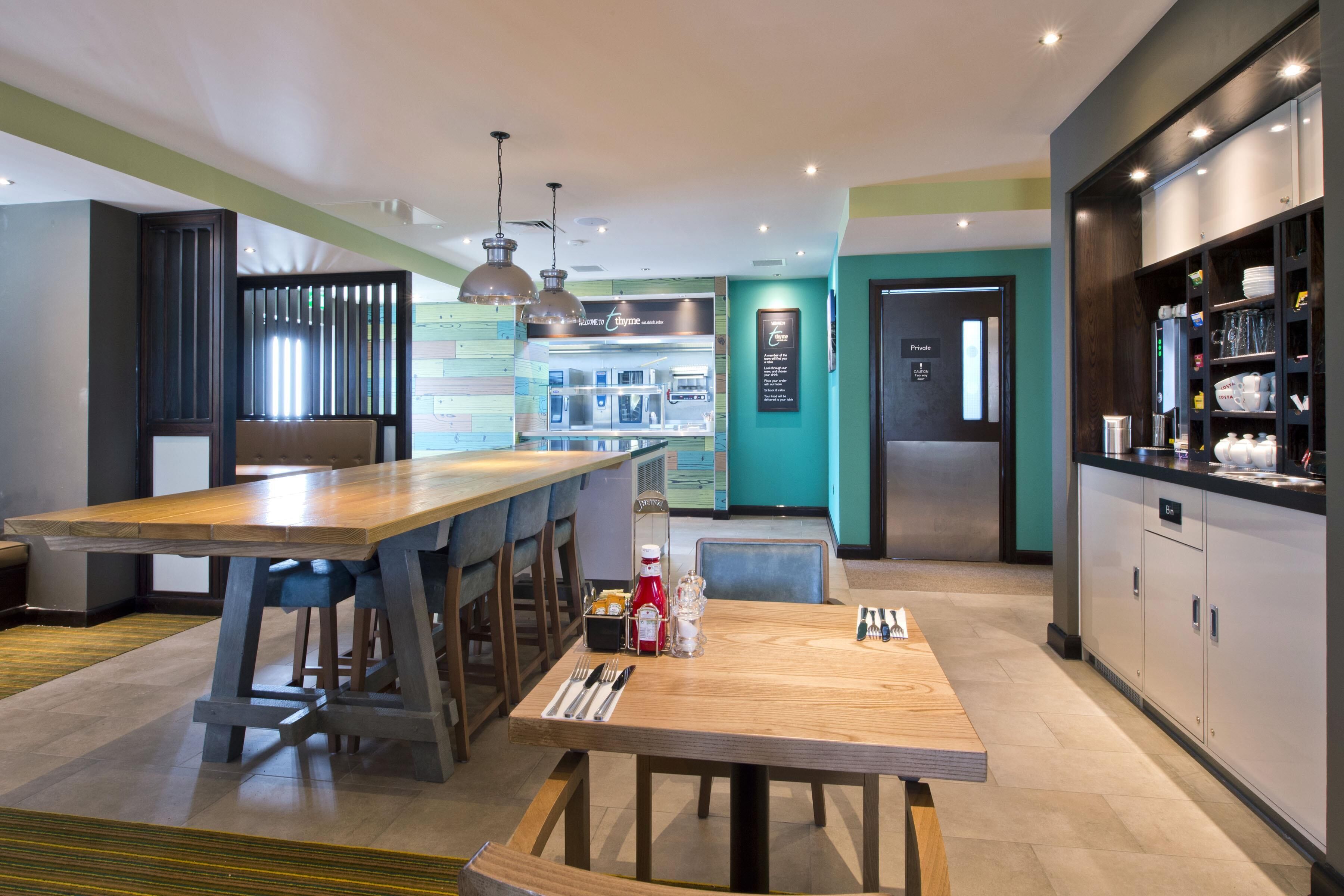 A modern kitchen with a central island, bar stools, and a seating area.