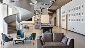 Ein modernes Interieur mit einer Wendeltreppe, einer Bibliothek und einer Wand voller gerahmter Bilder.