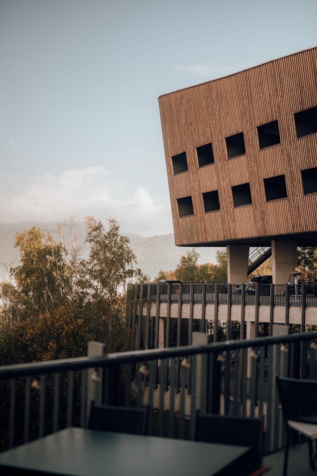 A modern building with a wooden facade and multiple windows.