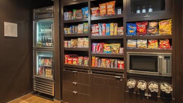 A vending machine area with snacks, beverages, and a microwave.